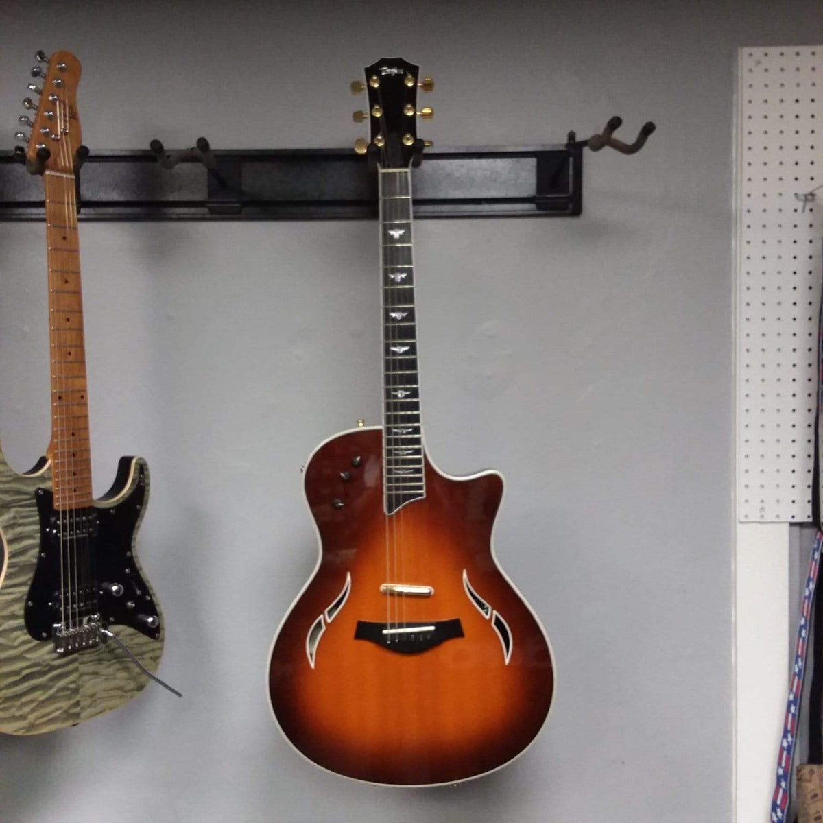 Taylor T5-C 2006 guitar with Custom Fishman Matrix Piezo pickup, displayed on a wall with another guitar, includes case.