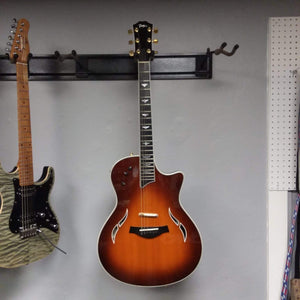 Taylor T5-C 2006 guitar with Custom Fishman Matrix Piezo pickup, displayed on a wall with another guitar, includes case.