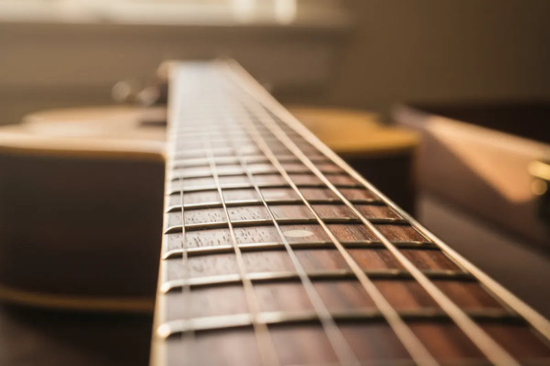 A view of a guitar neck leading to the guitar body.