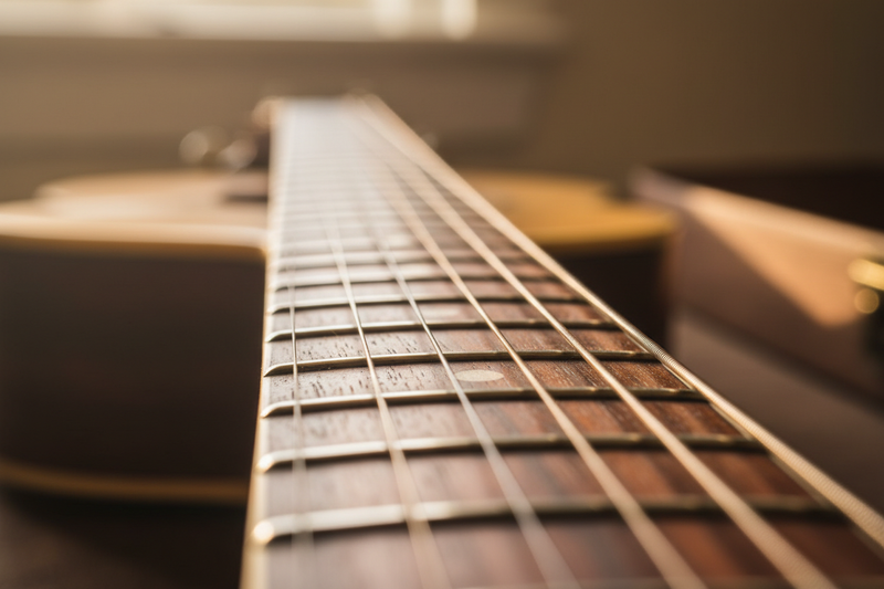 A view of a guitar neck leading to the guitar body.
