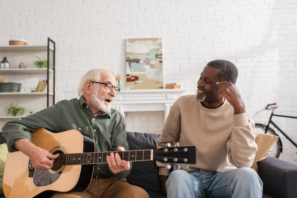 Two senior friends enjoying guitar