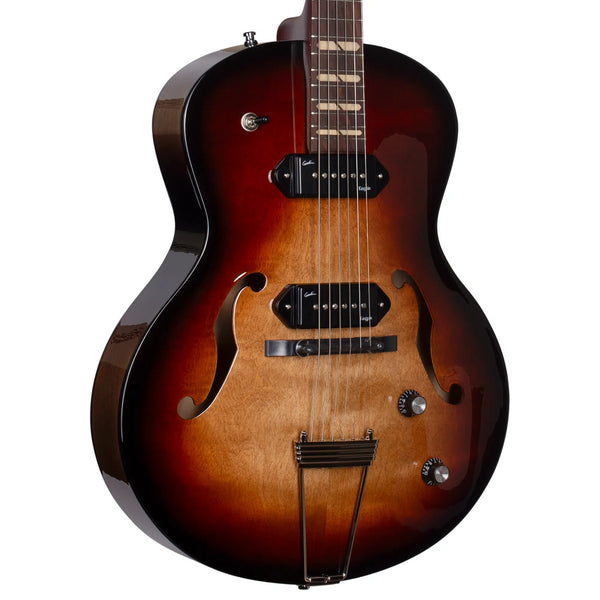 The Godin 5th Avenue Kingpin II DLX Vintage Burst HG SF is a sunburst hollow body electric guitar with f-holes, two pickups, control knobs, a trapeze tailpiece, and renowned Canadian craftsmanship.