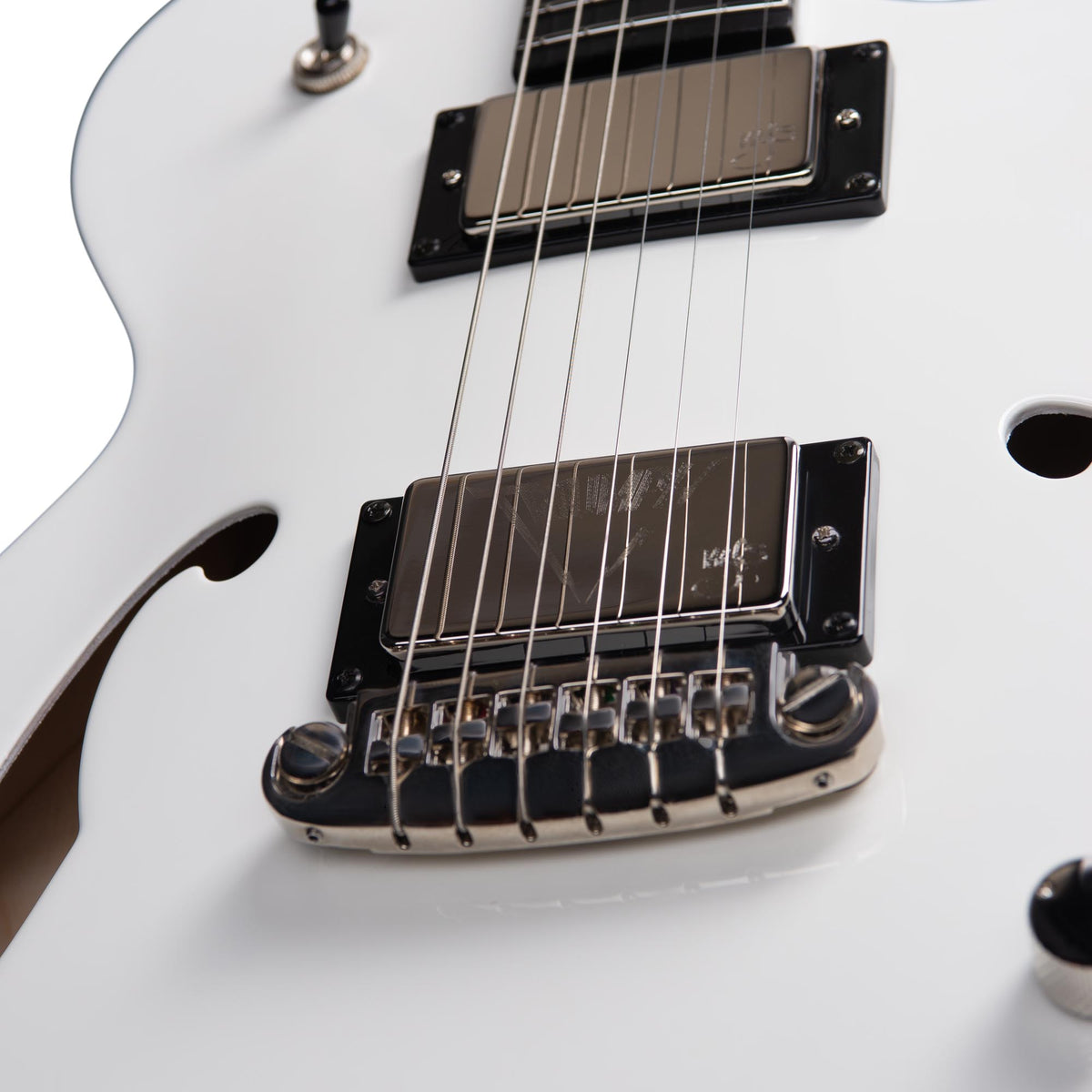 Close-up view of the bridge, pickups, and strings on a white Godin Rik Emmett Premiere Electric Guitar by Godin.