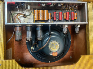 Interior view of the 1954 Fender Tweed Deluxe Model 5D3 by Guitars on Main shows vacuum tubes, capacitors, resistors, speaker, and hand-wired components inside this vintage amp’s cabinet. Comes with a flight case.