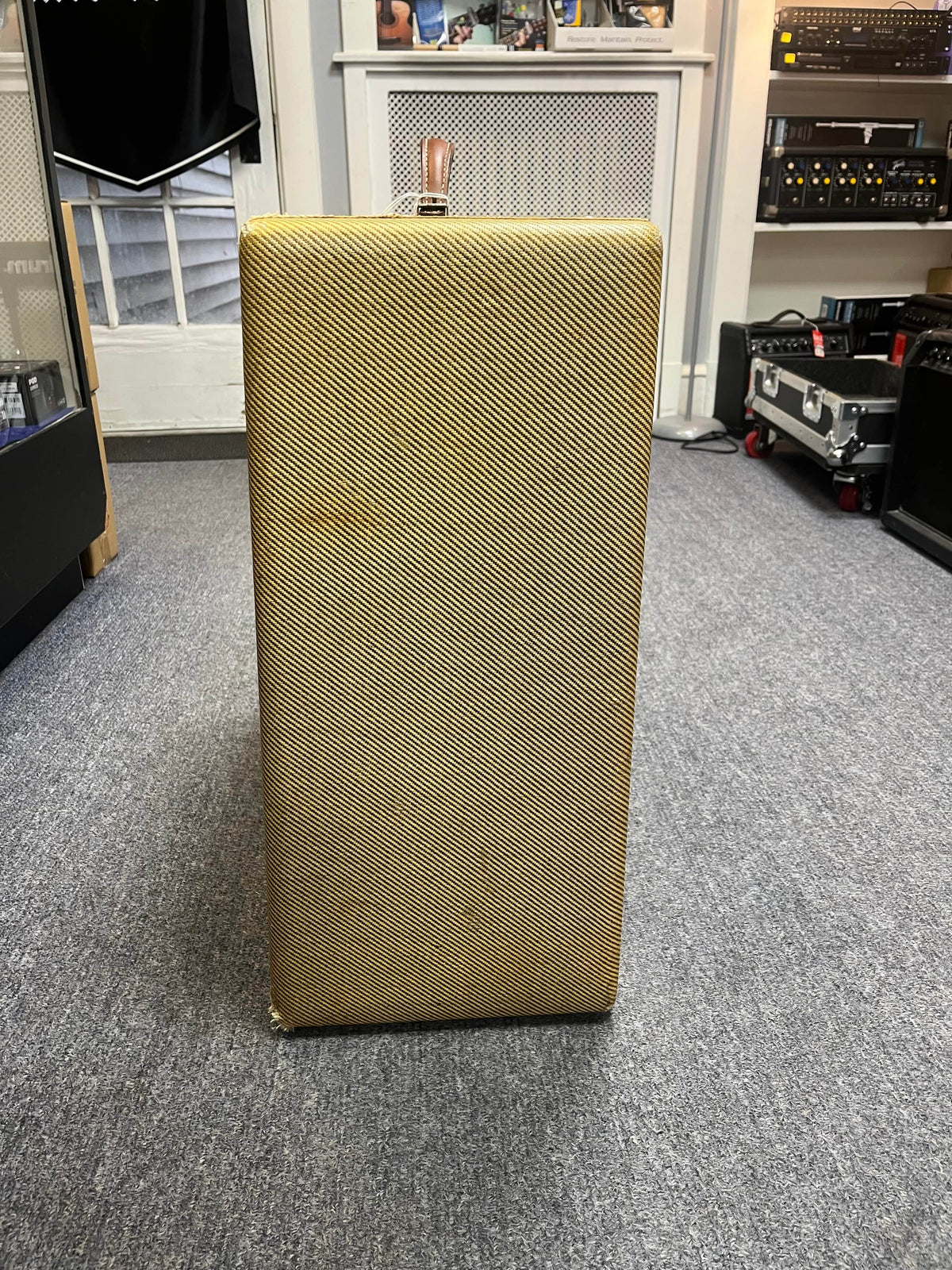 A Fender 1957 Bassman 5F6 Narrow Panel 40-Watt 4x10" combo amp with tan textured covering stands upright on a gray carpeted floor in a music studio.