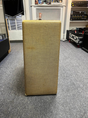A Fender 1957 Bassman 5F6 Narrow Panel 40-Watt 4x10" combo amp with tan textured covering stands upright on a gray carpeted floor in a music studio.