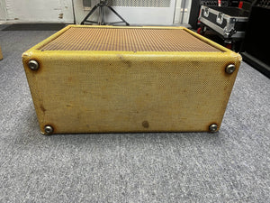 A Fender 1957 Bassman 5F6 Narrow Panel 40-Watt 4x10" Guitar Combo with flight case rests on its side on a gray carpet in a music studio.