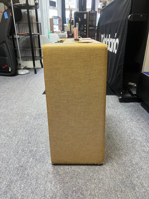 A 1957 Fender Bassman 5F6 Narrow Panel 40-Watt 4x10" Guitar Combo w/Flight Case by Fender, featuring vintage tweed style, stands in a music store, evoking the iconic sound and design of the classic '57 era.