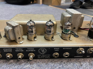 Close-up of the back panel on a 1965 Fender Deluxe Reverb AB763 (Pre-CBS Blackface, Serial A 06439) highlights its vacuum tubes, input/output jacks, and detailed control labels.