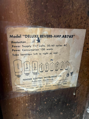 The label on the 1965 Fender Deluxe Reverb AB763 (Pre-CBS Blackface, Serial A 06439) shows power specs, a tube layout diagram, and manufacturing details from Fullerton—exemplifying this classic vintage Fender amp.