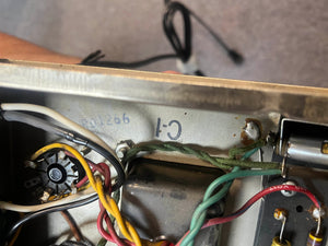 Close-up of the 1965 Fender Deluxe Reverb AB763 (Pre-CBS Blackface, Serial A 06439) interior: colored wires, a rotary component, and "C-1" marked on the metal—all classic Fender craftsmanship.