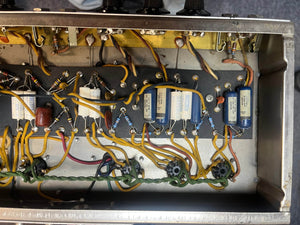 Close-up of electronic components inside the metal chassis of a Fender 1965 Deluxe Reverb AB763 Pre-CBS Blackface (Serial A06439), showcasing capacitors, resistors, and wires in this classic Fender amp.