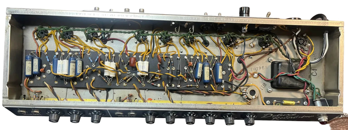 Top-down view of the interior circuitry in a 1965 Fender Deluxe Reverb AB763 Pre-CBS Blackface (Serial A 06439), showing wires, components, and control knobs along the bottom edge.