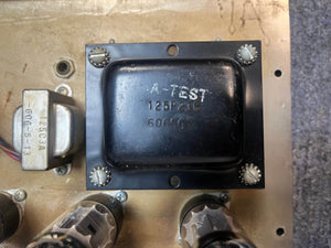 Close-up of a black metal transformer labeled "A-TEST 125P23C 606611" mounted on a beige chassis—typical of components in vintage tube amps like the Fender 1965 Deluxe Reverb AB763 Pre-CBS Blackface Serial A 06439.