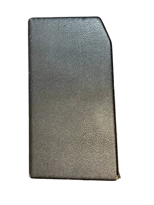 A closed black book with a textured cover and slanted top-right corner, standing upright against a white background, echoes the iconic 1965 Fender Deluxe Reverb AB763 -- Pre-CBS Blackface Serial A 06439 by Fender.