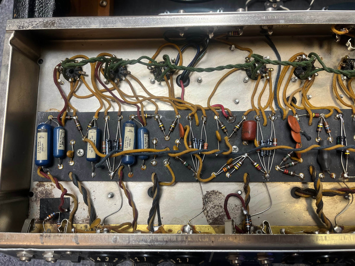 Interior view of the 1965 Fender Super Reverb - Black Panel - "Player’s Dream" Restoration by Guitars on Main showing classic resistors, capacitors, wires, and soldered joints—craftsmanship behind its legendary Blackface sound.