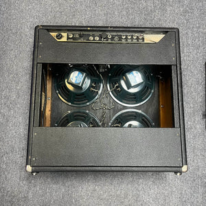 The 1965 Fender Super Reverb - Black Panel, offered by Guitars on Main, showcases four speakers behind a rear open panel and classic wiring, all set on a gray carpet. Local pickup available; enjoy iconic vintage sound and style.