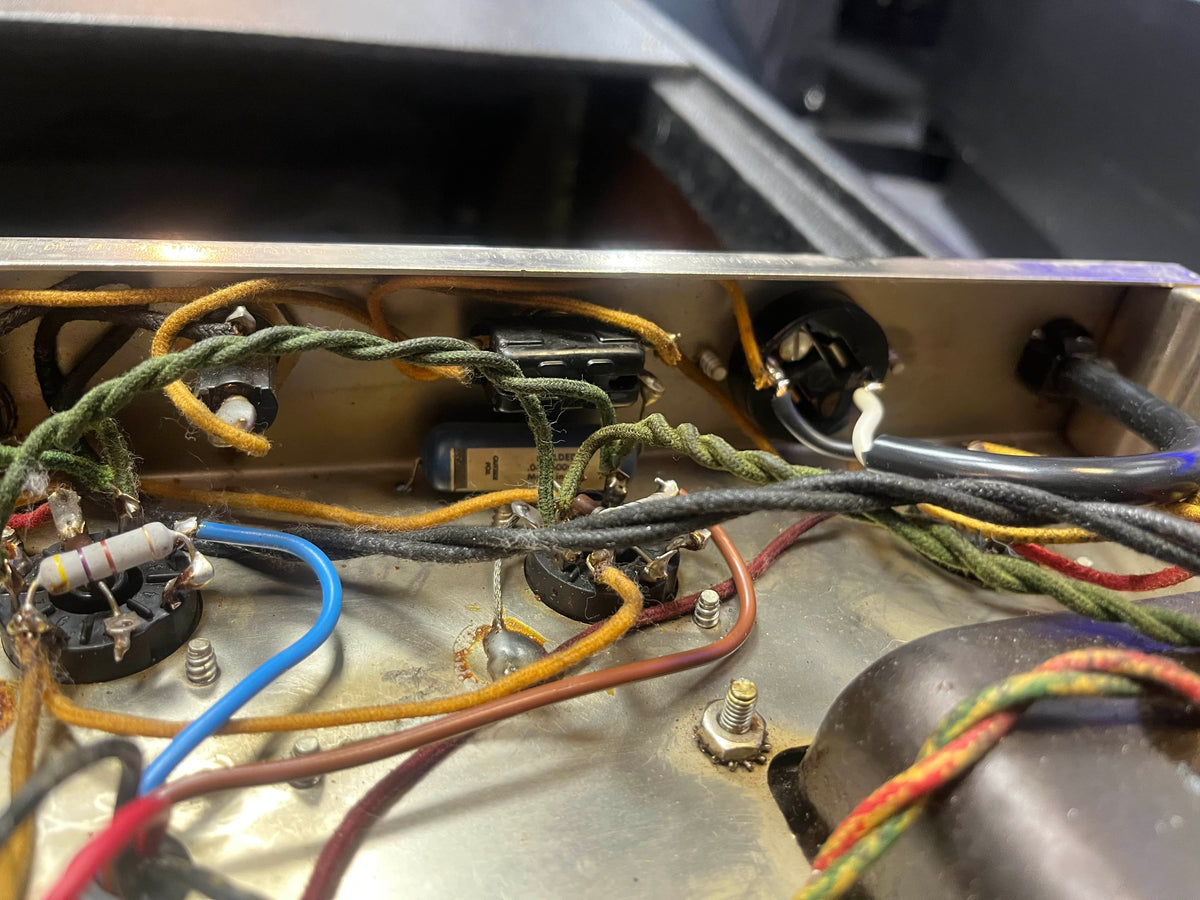 Close-up of vintage electronic wiring, resistors, and sockets inside the 1965 Fender Super Reverb - Black Panel - "Player’s Dream" Restoration by Guitars on Main, showcasing classic Blackface amp craftsmanship.
