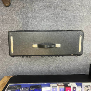A 1965 Fender Super Reverb Black Panel amp head from Guitars on Main rests on a gray carpet, evoking vintage tones, with several guitar pedals visible below. Available for local pickup.