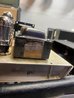 Close-up of a metal transformer and vacuum tube marked "IW42" on an electronic chassis, reminiscent of the legendary 1965 Fender Super Reverb - Black Panel from Guitars on Main, available for local pickup.