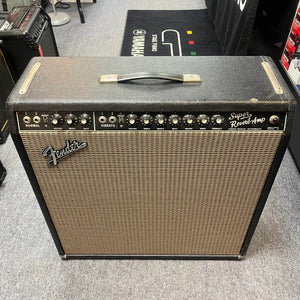 This 1965 Fender Super Reverb - Black Panel amp by Guitars on Main features top-panel knobs and switches, displayed on a carpeted floor in our music equipment store. Available for local pickup.