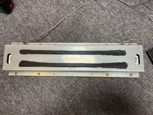 A reverb tank  of a 1965 Fender Super Reverb - Black Panel - "Player’s Dream" Restoration by Guitars on Main, placed on gray carpet with attached wires.