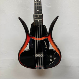 The 1966 Ampeg ASB-1 Devil Bass (Serial #531) is a vintage electric bass guitar featuring a striking sunburst finish and unique horned body shape inspired by the iconic Ampeg design. This classic model comes equipped with three control knobs, a black pickguard, and a bridge-mounted transducer pickup for enhanced tonal versatility. Includes case.