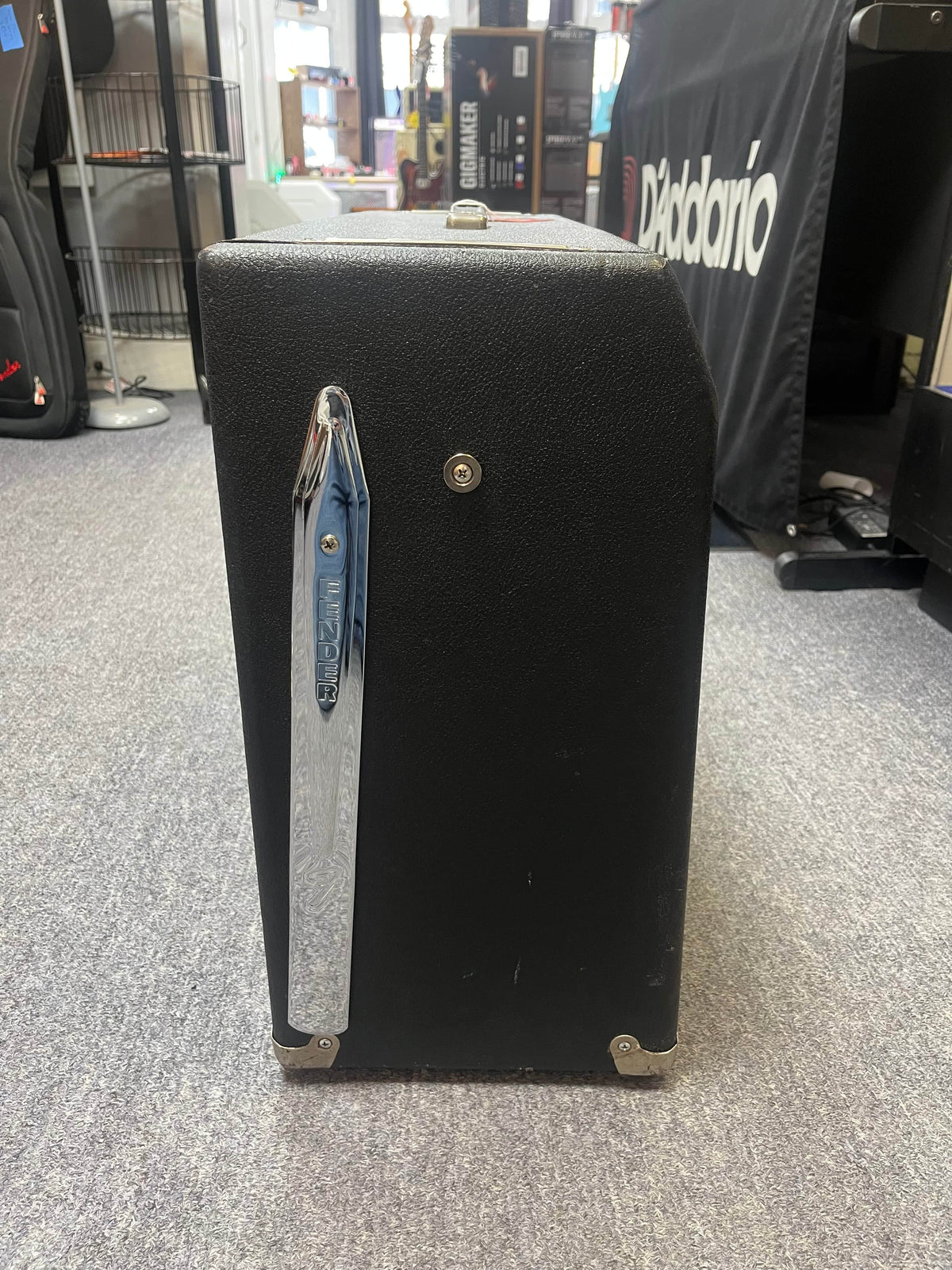 A 1966 Fender Twin Reverb 2-Channel 85-Watt 2x12" Guitar Combo Amp w/Flight Case stands upright on a gray carpeted floor in a music store.