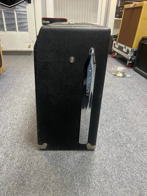 A 1966 Fender Twin Reverb 2-Channel 85-Watt 2x12" Guitar Combo Amp by Fender, with a chrome handle and flight case, sits on a gray carpeted floor among other musical gear.