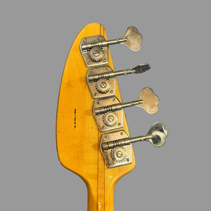 Close-up of the back of a 1967-68 Vox Sidewinder IV Bass (V272) Cherry headstock by Vox, featuring four silver tuning pegs against a plain gray background.