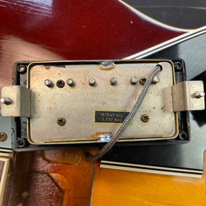 1967 Gibson ES-335 Sunburst electric guitar close-up, showcasing metal hardware and semi-hollow body design. Comes with a protective case.