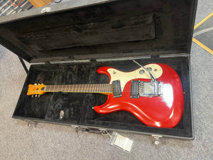 The 1967 Mosrite Mark I Vintage Guitar by Mosrite, featuring a red finish, white pickguard, and tremolo arm, is displayed in an open black hard case lined with soft black fabric.