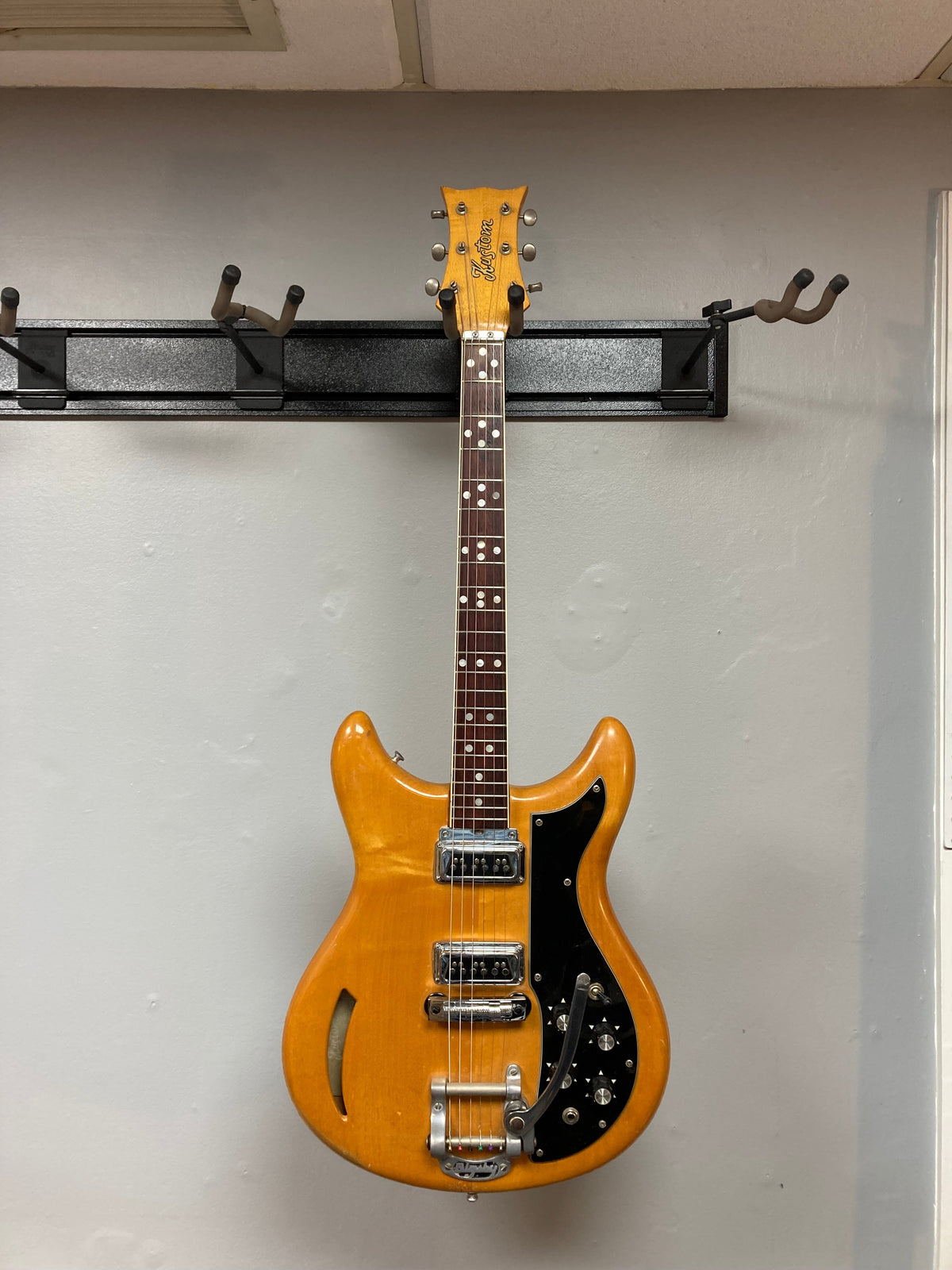 1968 Kustom K-200A Vintage Guitar w/OHSC, displayed on a wall, featuring DeArmond Dyna-Sonic pickups and Bigsby vibrato.