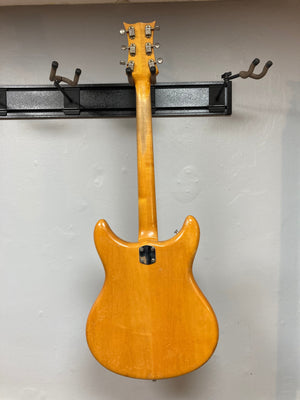 1968 Kustom K-200A Vintage Guitar displayed on a wall, showcasing its semi-hollow body, wide headstock, and Bigsby vibrato.