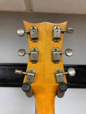 1968 Kustom K-200A vintage guitar close-up, showcasing its semi-hollow body and metal hardware, highlighting DeArmond Dyna-Sonic humbucking pickups and Bigsby vibrato.