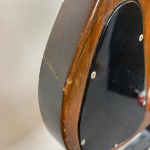 Close-up of a 1975 Gibson SG Standard Walnut guitar, showcasing its bevelled mahogany body, mother of pearl inlays, and vintage hardware.