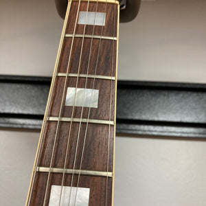 Close-up of the 1975 Gibson SG Standard Walnut guitar neck and strings, showcasing its detailed craftsmanship and iconic design.