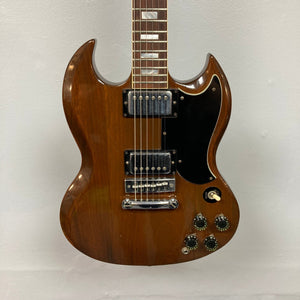 Close-up of a 1975 Gibson SG Standard Walnut electric guitar, highlighting strings, knobs, and pickguard, showcasing its detailed craftsmanship.