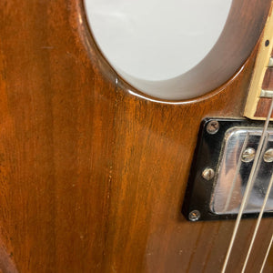 Close-up of a 1975 Gibson SG Standard Walnut guitar with detailed fretboard and pickups.