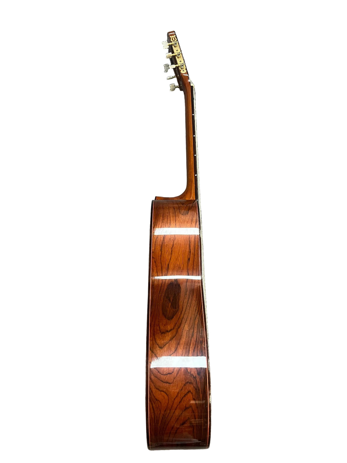 Side view of a 1976 S. Yairi No. 880 Classical Guitar by S Yairi, made in Japan, highlighting its Brazilian rosewood body, neck, and tuning pegs against a white background.