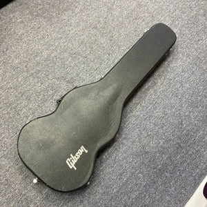 A 1977 Gibson SG Standard Cherry with its original Gibson hard case lies closed on a gray carpeted floor.