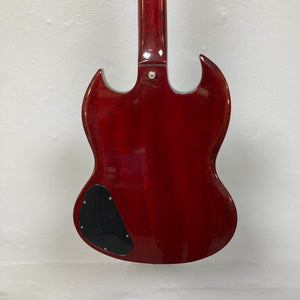The back of a 1977 Gibson SG Standard Cherry electric guitar by Gibson is shown against a white wall, highlighting its double cutaway mahogany body. A black plastic control cover appears on the lower left side, echoing the classic style of the Gibson Kalamazoo era.