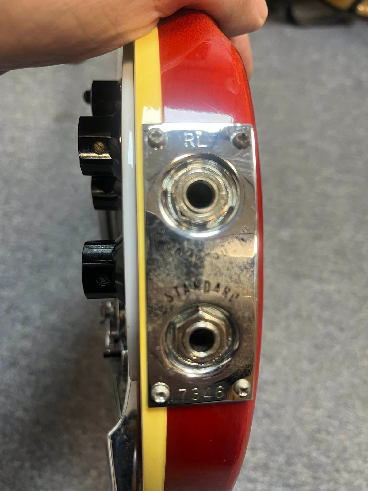 Close-up of the side of a 1978 Rickenbacker 4001 Bass in Fireglo (Serial RL7346), showing two input jacks on a metal plate labeled "STANDARD.
