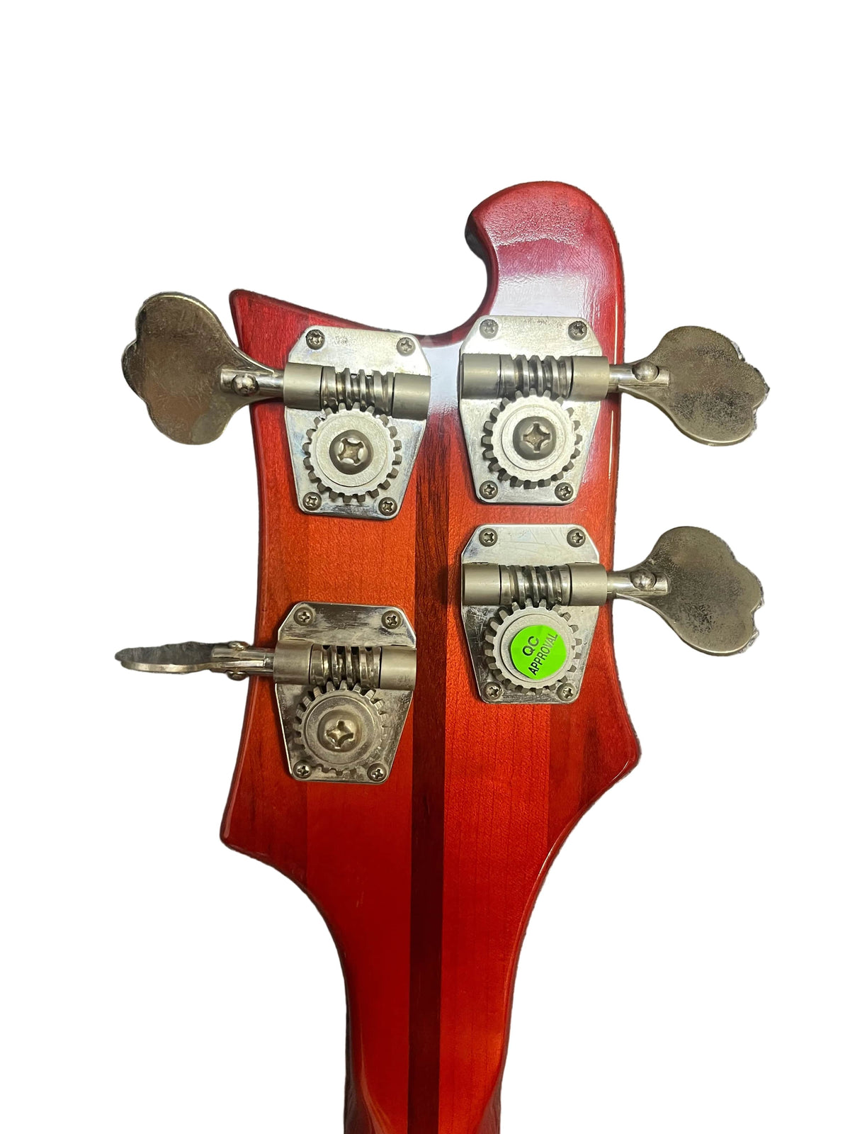 Close-up of the back of a 1978 Rickenbacker 4001 Bass — Fireglo (Serial RL7346) headstock, showing four metal tuning pegs and a green inspection sticker, isolated on white.