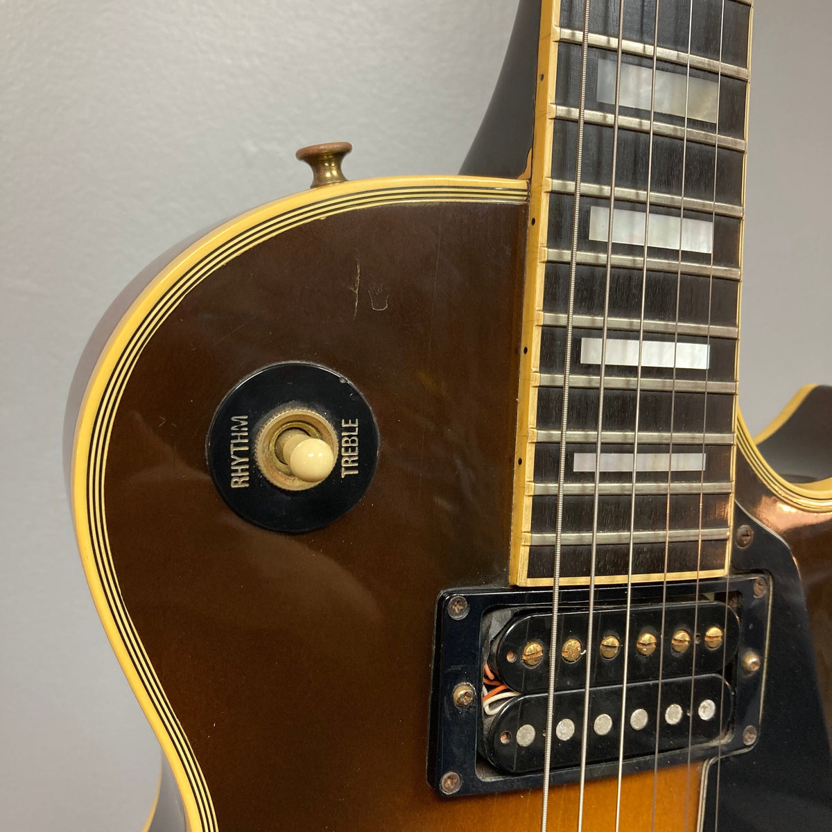Close-up of the 1980 Gibson Les Paul Custom’s upper body, showcasing the rhythm/treble switch, strings, and fretboard in the iconic Tobacco Sunburst finish.