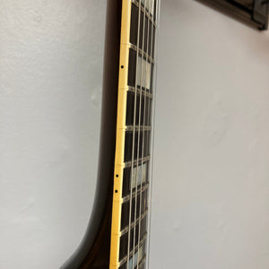 Close-up of a 1980 Gibson Les Paul Custom – Tobacco Sunburst neck showing frets, side dot markers, and cream binding, set against a plain light wall.