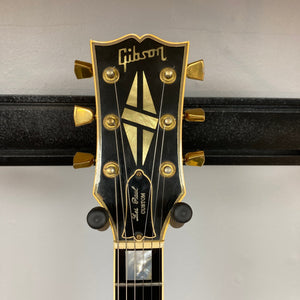 Close-up of a 1980 Gibson Les Paul Custom – Tobacco Sunburst headstock by Gibson, showing gold tuning pegs, inlay designs, Gibson logo, and "Les Paul Custom" truss rod cover on a black background; includes original hard shell case (OHSC).