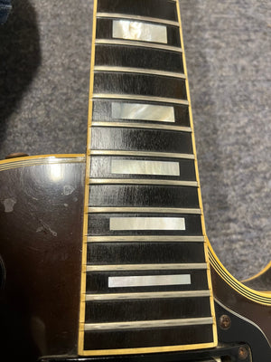 Close-up of a 1980 Gibson Les Paul Custom showing rectangular mother-of-pearl inlays, dark fretboard, and worn body with classic Tobacco Sunburst finish. Brand: Gibson. Model: Les Paul Custom – Tobacco Sunburst w/OHSC.
