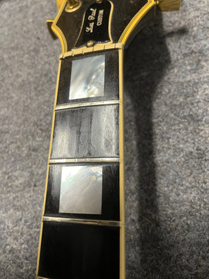 Close-up of a 1980 Gibson Les Paul Custom – Tobacco Sunburst w/OHSC by Gibson, featuring three mother-of-pearl inlays on a dark fretboard, gold hardware, and part of the headstock—a classic vintage Les Paul.