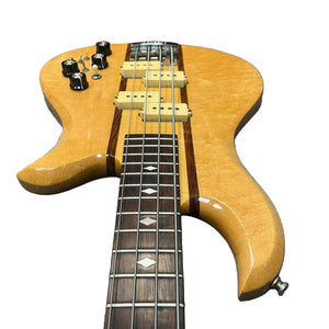 A close-up of a 1982 B.C. Rich Eagle Bass—USA made, with original electronics, natural wood finish, neck-through build, four control knobs, dual pickups, and diamond inlays—professionally set up.